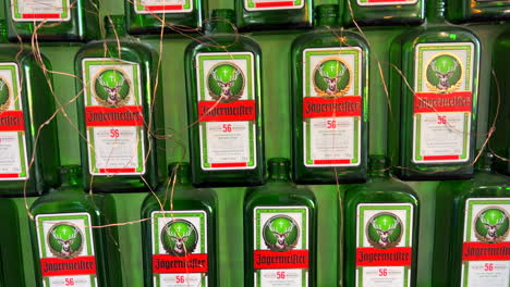 Viele-Jägermeister-Deutsche-Digestif-Alkoholgrünflaschen-An-Einer-Wand,-Alkoholisches-Getränk,-4K-Aufnahme