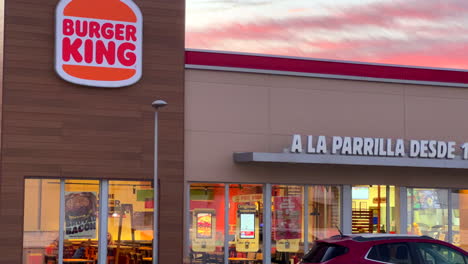 Beautiful-pink-orange-sunset-at-Burger-King-restaurant-entrance-in-Estepona-Spain,-amazing-sunset,-4K-shot