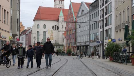 Escena-De-Gente-Caminando-En-Maximilianstrasse-Cerca-De-La-Iglesia-Católica-De-Saint-Moritz-Y-Weberhaus-En-Augsburgo,-Alemania