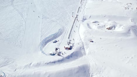 Drone-shot-of-skiers-having-fun-on-the-slopes-and-using-the-ski-lifts-at-Farellones,-Chile