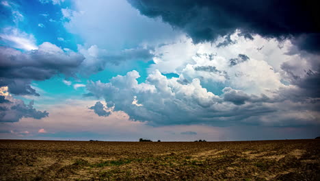 Vibrant-storm-clouds-flowing-above-rural-landscape,-time-lapse-view