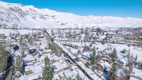 Aerial-hyperlapse-in-orbit-with-parallax-effect-on-the-completely-snowy-mountain-village-of-Farellones,-snow-capped-mountains-in-the-background,-Chile