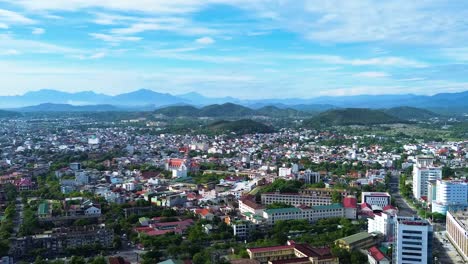 Aerial-establishing-shot-overhead-downtown-Hue-with-large-mountains-in-the-city