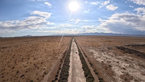 Lonely,-dirt-road-in-the-Mojave-Desert-wilderness---ascending-aerial-reveal