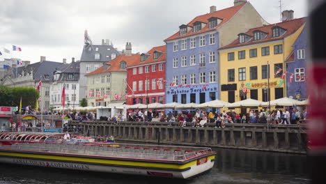 Un-Barco-Turístico-Se-Desliza-Por-Nyhavn-Y-Ofrece-Impresionantes-Vistas-De-Las-Coloridas-Casas-Junto-Al-Canal.