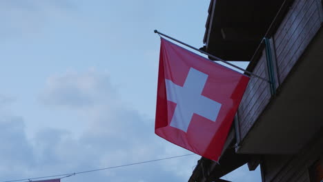 Swiss-flag-on-house-balcony-in-Lauterbrunnen,-Switzerland