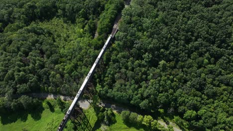 An-aerial-view-of-the-Moodna-Viaduct,-a-steel-railroad-trestle-in-Cornwall,-NY-with-a-train-on-it