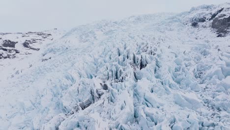 Luftaufnahme-Der-Landschaft-über-Eisformationen-Im-Schneebedeckten-Falljökull-Gletscher,-Island,-In-Der-Abenddämmerung