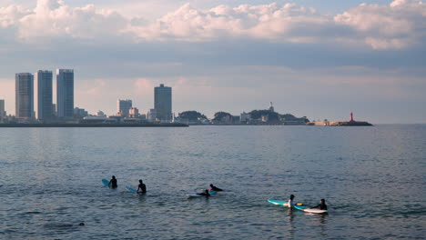 Gente-Flotando-Con-Tablas-De-Surf-En-La-Playa-De-Sokcho-En-La-Provincia-De-Gangwon,-Corea-Del-Sur.