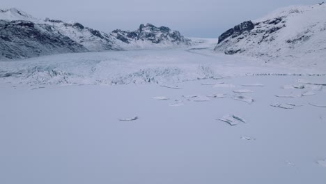 Aerial-landscape-view-over-iceberg-in-Skaftafellsjokull-glacier-covered-in-snow,-Iceland