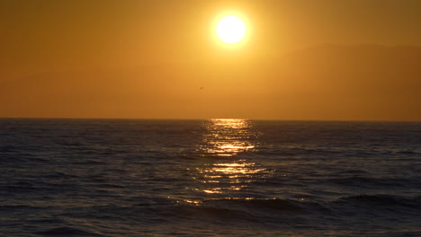 Golden,-fiery,-glowing-sun-reflecting-off-the-ocean-at-sunset