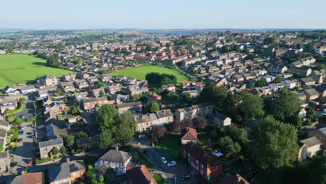 Dewsbury-Moore-Council-estate's-essence,-captured-by-a-drone:-red-brick-housing-and-the-industrial-Yorkshire-backdrop-on-a-sunny-summer-morning