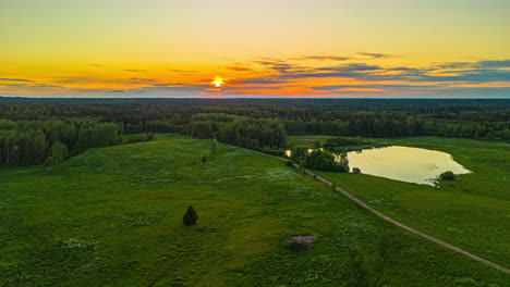 Golden-sunset-over-with-a-brilliant-sky-reflecting-off-a-pond---aerial-hyper-lapse