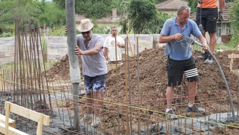 El-Equipo-De-Construcción-Añade-Hormigón-Premezclado-A-Los-Cimientos-De-La-Zanja-Reforzada.