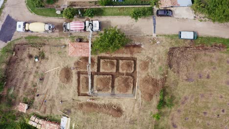 La-Bomba-De-Pluma-Entrega-Concreto-Premezclado-Al-Terreno-De-Construcción-Aéreo-De-Arriba-Hacia-Abajo