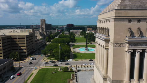 Luftaufnahme-Vorbei-Am-Indiana-War-Memorial-Und-Museum,-In-Richtung-Obelisk-Square-Im-Sonnigen-Indianapolis,-USA