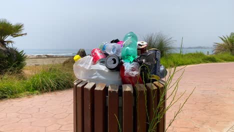 Überfüllter-Müllcontainer-Am-Strand,-Menschen,-Die-Keinen-Müll,-Plastik-Und-Flaschen-In-Marbella,-Spanien,-Recyceln,-4K-Aufnahme