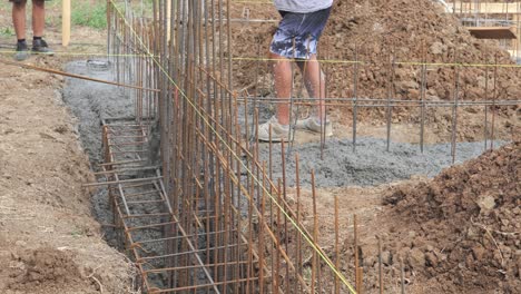 House-builder-pours-concrete-into-house-foundation-reinforced-trench