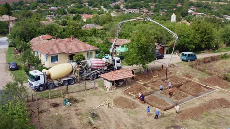 Ready-mixed-concrete-trucks-with-boom-machine-delivers-to-building-plot-drone