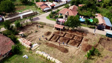 Building-site-with-ready-mixed-concrete-trucks-with-long-reach-boom-drone-shot