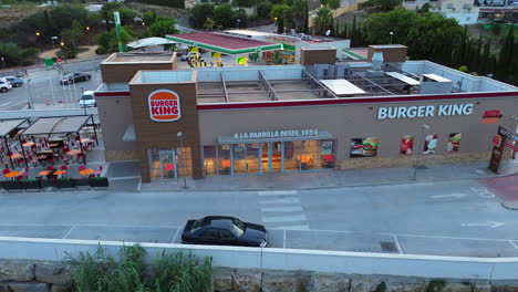 Aerial-view-of-Burger-King-and-Auto-King-drive-through-in-Estepona-Spain,-fast-food-restaurant,-4K-shot