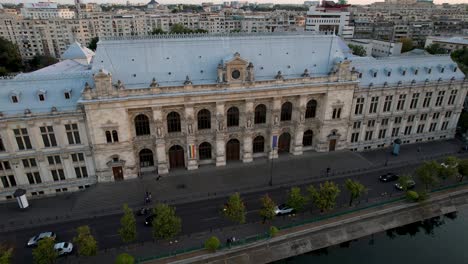 Puesta-De-Sol-Sobre-El-Palacio-De-Justicia-Y-El-Río-Dambovita-En-Bucarest,-Rumania,-Vista-Aérea