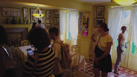 Check-out-this-perspective-of-folks-exploring-Claude-Monet's-yellow-dining-room-located-in-his-cozy-abode-in-Giverny,-France