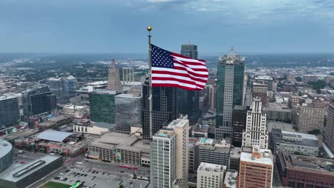 Bandera-Americana-Ondeando-En-Un-Alto-Rascacielos-En-El-Centro-De-La-Ciudad-De-Kansas,-Mo