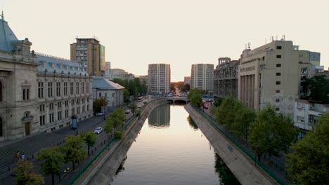 Puesta-De-Sol-Sobre-El-Palacio-De-Justicia-Y-El-Río-Dambovita-En-Bucarest,-Rumania,-Vista-Aérea