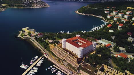 An-exceptional-drone-perspective-of-Frankopan-Castle,-combined-with-a-city-view-and-stunning-coastlines-filled-with-superb-yachts,-offers-a-delightful-view-over-the-seascape,-Kraljevica,-Croatia