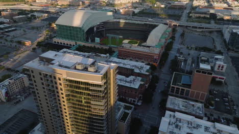 Aerial-view-tilting-toward-the-Minute-maid-Park,-golden-hour-in-Houston,-Texas,-USA