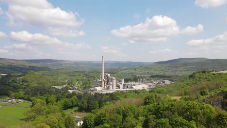 Aerial-drone-flight-heading-towards-the-main-building-of-Breedon-Hope-Cement-Works-with-a-panoramic-view-of-the-surrounding-Peak-District
