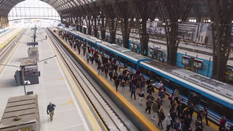 People-walk-on-platform-at-Retiro-train-station-in-Argentina,-aerial