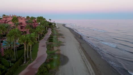 aerial-view-beautiful-sunset-beach-walk-spanish-shoreline,-andalucia,-estepona-marbella-,malaga-vacation-peaceful
