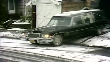 1980-Coche-Fúnebre-Con-Ataúd-Saliendo-Hacia-La-Carretera-Cubierta-De-Nieve