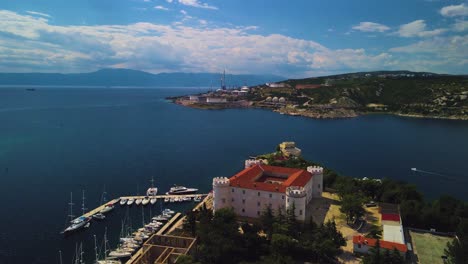 An-exceptional-drone-perspective-of-Frankopan-Castle,-combined-with-a-city-view-and-stunning-coastlines-filled-with-superb-yachts,-offers-a-delightful-view-over-the-seascape,-Kraljevica,-Croatia