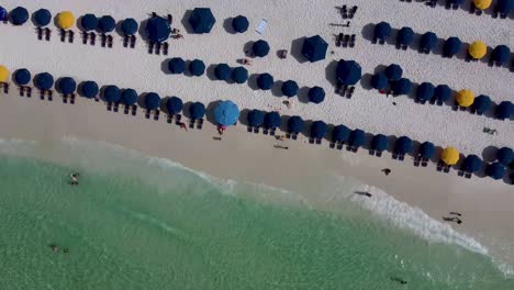 Aerial-view-of-people-relaxing-on-beach-umbrellas
