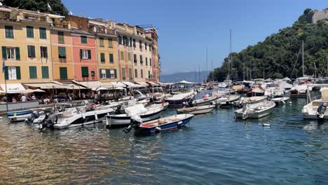 Panning-view-of-the-picturesque-colourful-houses,-sea-view-and-boats-mooring-in-waterfront-promenade-in-Portofino,-Italy
