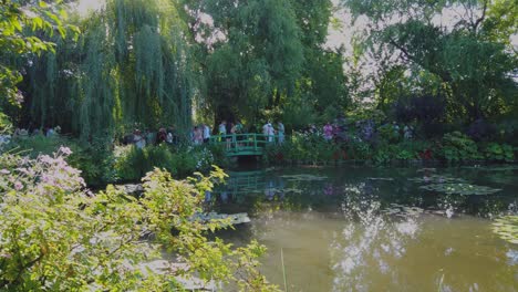 Ein-Bezaubernder-Anblick-Der-Seerosen-Und-Der-Brücke-Am-Teich-Von-Claude-Monet-In-Giverny,-Frankreich,-Lockt-Eine-Vielzahl-Von-Touristen-An,-Die-Die-Malerische-Aussicht-Erkunden