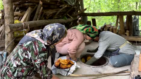 Hornear-Pan-Delicioso-Fresco-Y-Caliente-En-La-Arcilla-Antiguo-Horno-Tradicional-En-El-Bosque-Pueblo-Rural-Con-Familia-Mujeres-Vida-Libertad-Concepto-De-Vida-Nómada-Local-Temporada-De-Verano-Primavera-Verde-Aire-Fresco-Campamento-De-Fuego-De-Madera