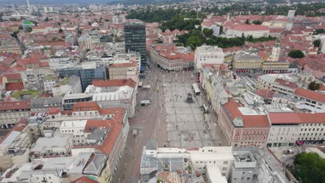 Aerial-view-circling-above-Ban-Jelačić-Square,-Zagreb,-Croatia-old-city-pedestrian-marketplace