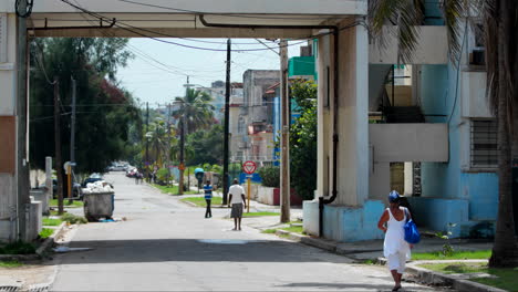 Locals-Walking-Along-Middle-Of-Road-In-Typical-Cuban-Street-On-Sunny-Day