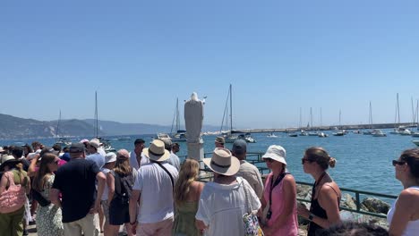 Tourists-waiting-orderly-in-line-on-the-pier-to-board-the-ferry-boat-to-Portofino-in-Santa-Margherita-Ligure,-Italy