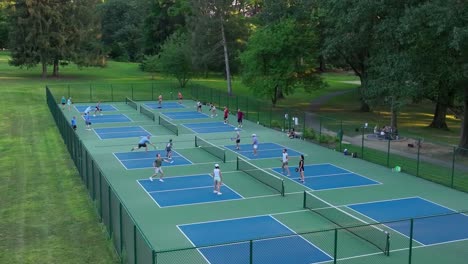 People-playing-pickleball-in-park-during-summer-evening