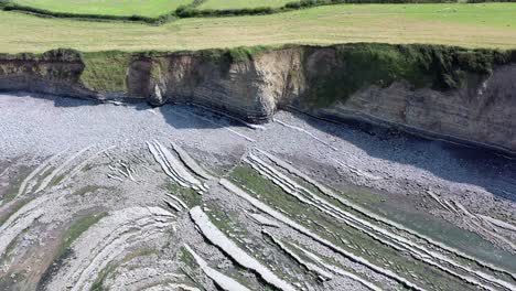 Drone-shot-while-moving-left-to-right-over-Kilve-beach-and-its-sea-cliffs-in-North-Devon,-UK