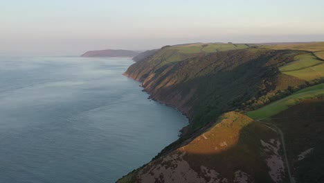 Drone-shot-moving-right-to-left-while-looking-a-the-North-Devon-coastline-a-sunset-in-the-UK