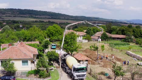 Cement-mixer-trucks-deliver-ready-mix-concrete-with-long-reach-boom-drone-shot