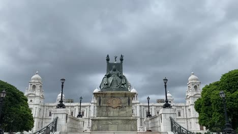 Tilt-up-shot-of-entrance-stairs-leading-up-to-the-statue-of-Queen-Victoria-sitting-in-front-of-Victoria-Memorial-in-Kolkata,-India-on-a-cloudy-day