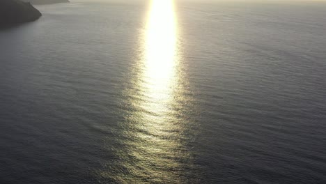 Drone-shot-looking-at-the-refection-of-sun-rays-on-the-ocean-from-sunset-on-the-North-Devon-coast-in-the-UK