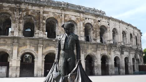 Bronze-statue-of-torero-matador-bull-fighter-in-front-of-Arena-of-Nimes-colosseum